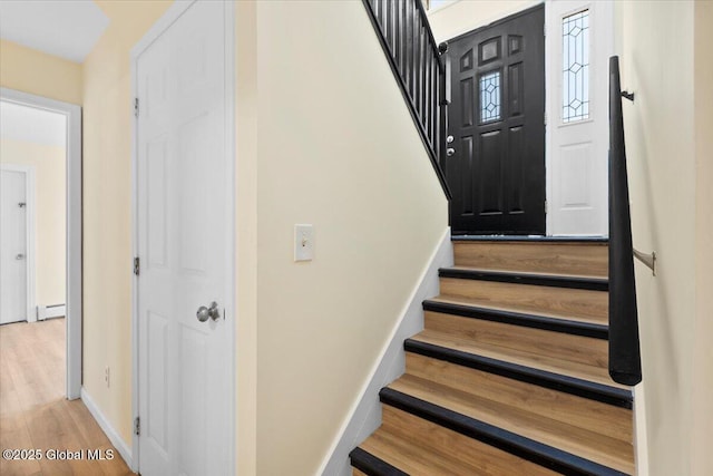 stairway featuring hardwood / wood-style flooring and a baseboard radiator