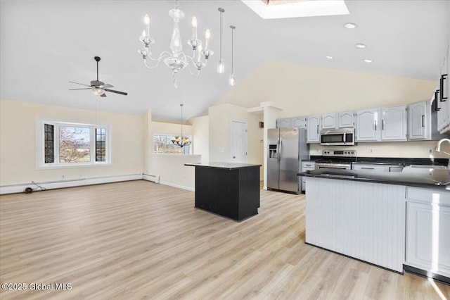 kitchen featuring a baseboard radiator, sink, light wood-type flooring, decorative light fixtures, and stainless steel appliances