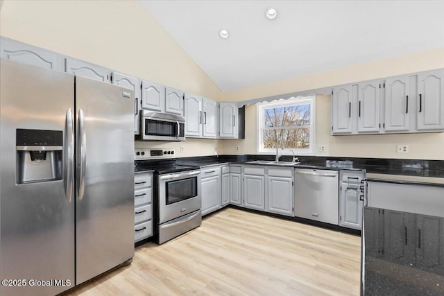 kitchen with stainless steel appliances, light hardwood / wood-style floors, sink, gray cabinets, and high vaulted ceiling