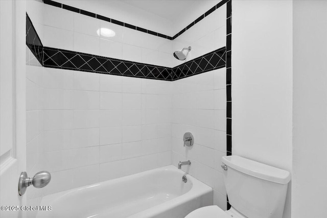 bathroom featuring toilet and tiled shower / bath