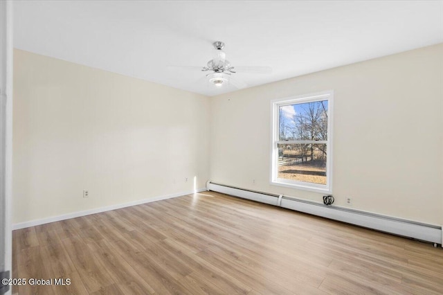 spare room featuring baseboard heating, light hardwood / wood-style floors, and ceiling fan