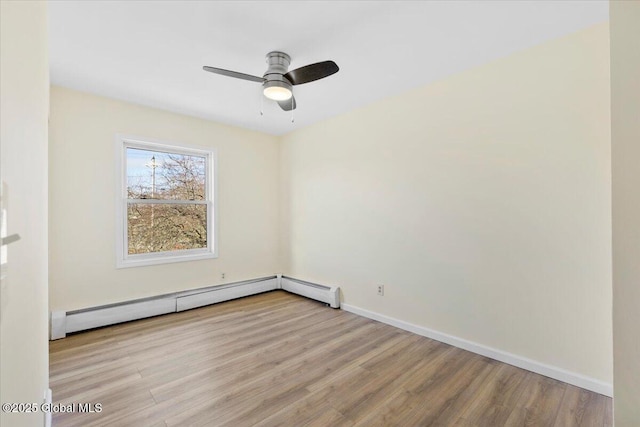 spare room with baseboard heating, light hardwood / wood-style flooring, and ceiling fan