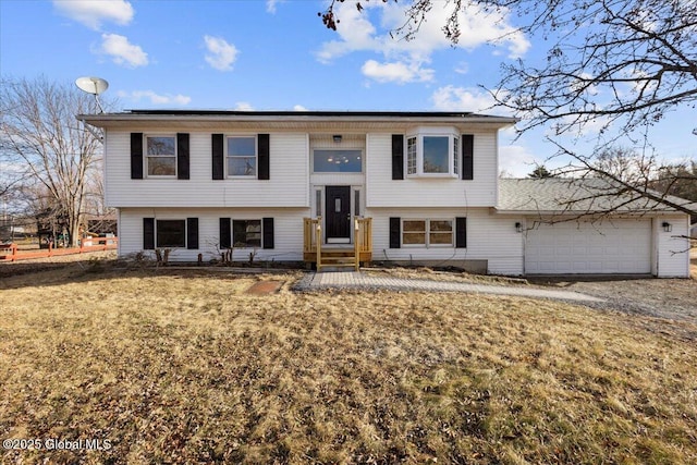 split foyer home featuring a garage and a front lawn