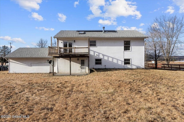 back of house featuring a wooden deck and a lawn