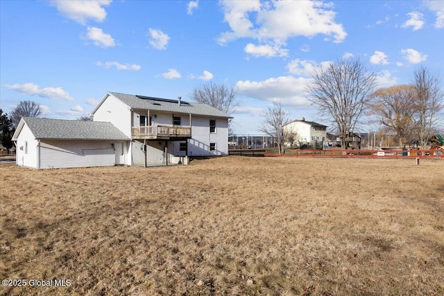 rear view of property with a wooden deck and a yard