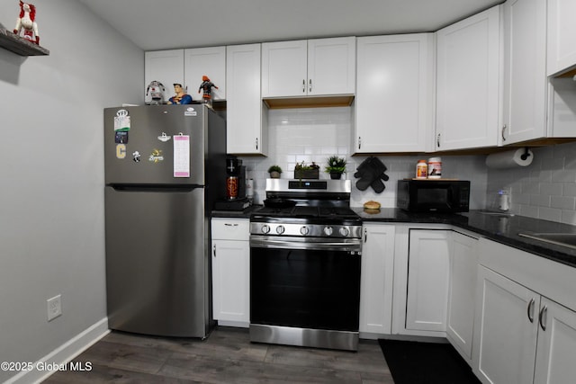 kitchen with appliances with stainless steel finishes, white cabinets, and backsplash