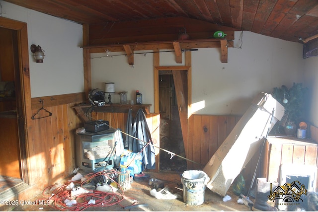 miscellaneous room featuring wooden walls, a wainscoted wall, and vaulted ceiling