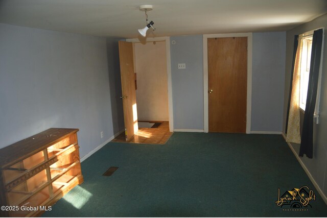 spare room featuring visible vents, carpet flooring, and baseboards