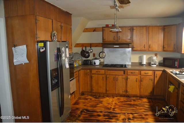 kitchen featuring brown cabinetry, black appliances, hanging light fixtures, and a sink