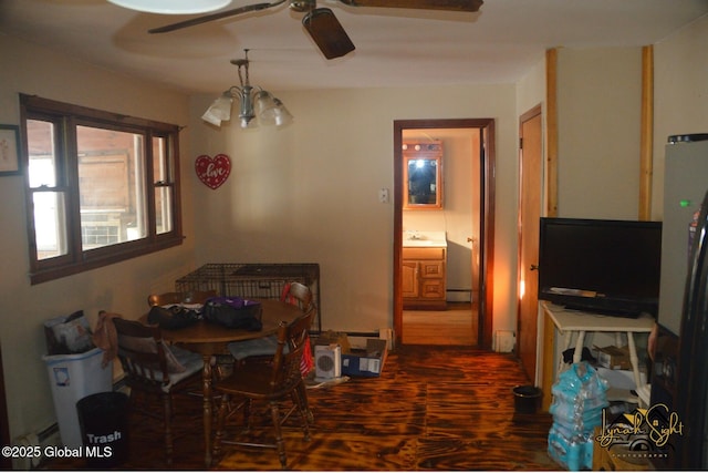 dining area featuring dark wood-style floors, baseboard heating, and ceiling fan