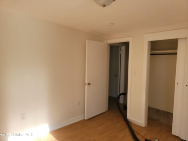 unfurnished bedroom with hardwood / wood-style floors and a closet