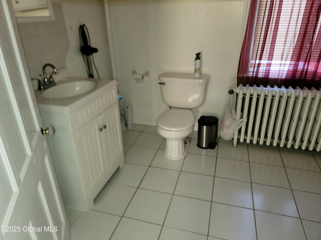 bathroom featuring tile patterned flooring, vanity, radiator heating unit, and toilet