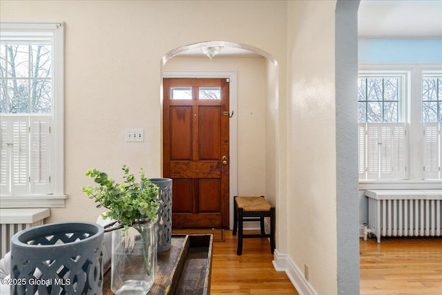 entrance foyer with radiator heating unit and light wood-type flooring