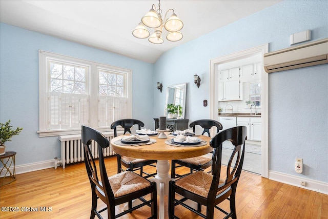 dining room featuring a wall mounted air conditioner, radiator heating unit, a chandelier, and light wood-type flooring