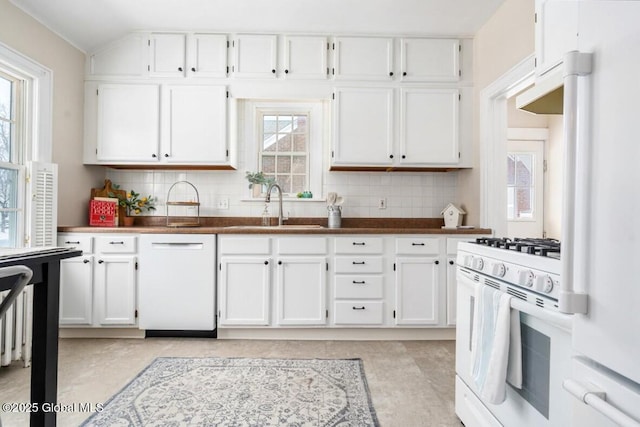 kitchen featuring backsplash, white appliances, sink, and white cabinets