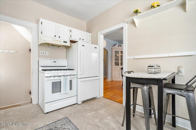 kitchen featuring white cabinetry, white appliances, and a breakfast bar