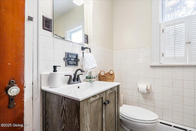 bathroom featuring tile walls, vanity, and toilet