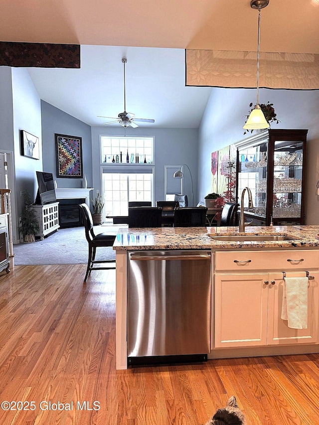 kitchen with vaulted ceiling with beams, light hardwood / wood-style floors, sink, hanging light fixtures, and stainless steel dishwasher