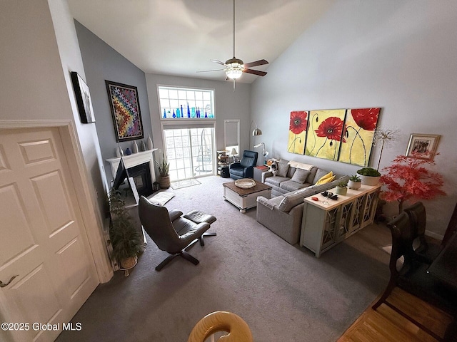 carpeted living room with ceiling fan and high vaulted ceiling