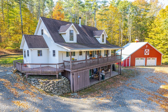 view of front facade with a wooden deck, a garage, and an outdoor structure