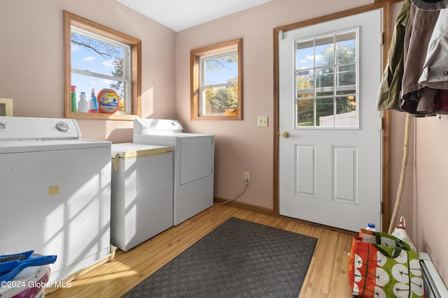 washroom with a baseboard radiator, light hardwood / wood-style floors, and washer and dryer