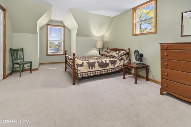 bedroom with lofted ceiling and light colored carpet