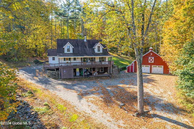 view of front of home featuring a garage, an outbuilding, and a wooden deck