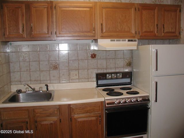 kitchen with range with electric stovetop, sink, backsplash, and white refrigerator