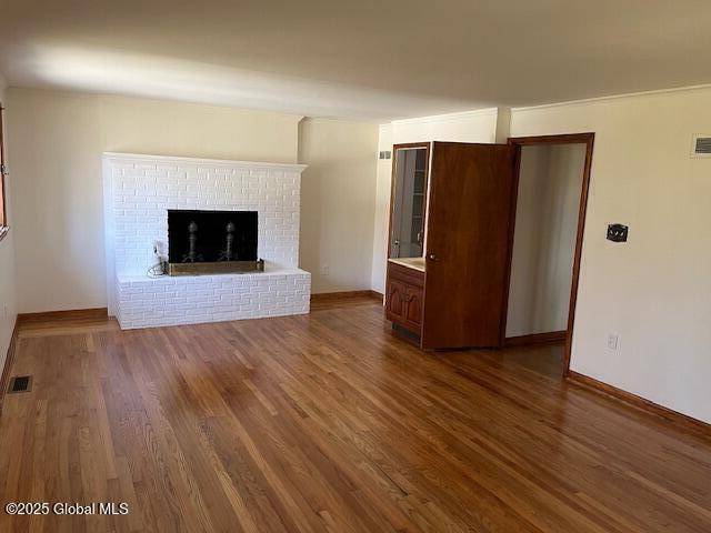 unfurnished living room featuring visible vents and dark wood-style flooring