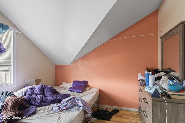 bedroom with vaulted ceiling and light hardwood / wood-style floors