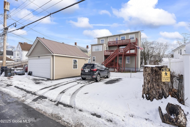 snow covered rear of property featuring an outdoor structure