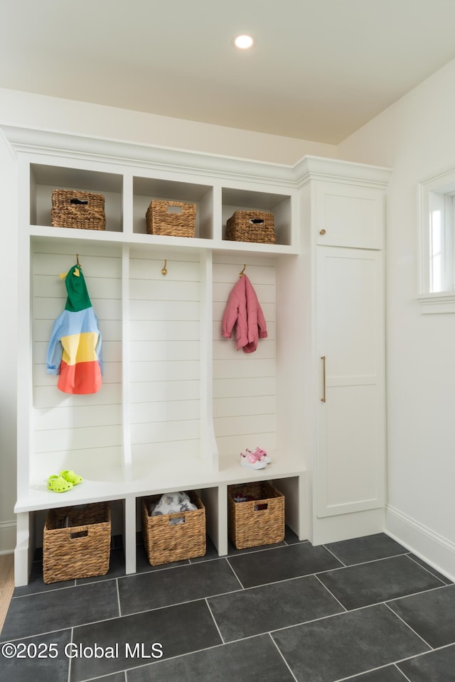 mudroom with dark tile patterned floors