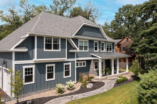 view of front of home featuring a porch, a garage, and a front lawn