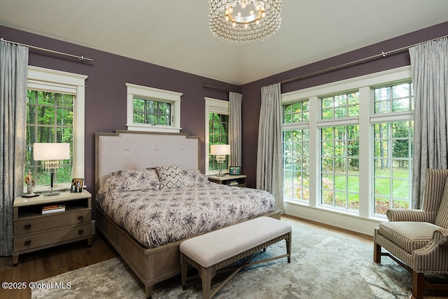 bedroom with hardwood / wood-style flooring and an inviting chandelier