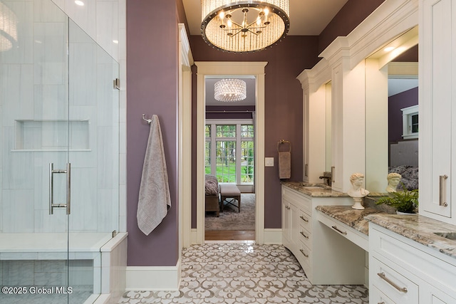 bathroom featuring an enclosed shower, vanity, and a notable chandelier