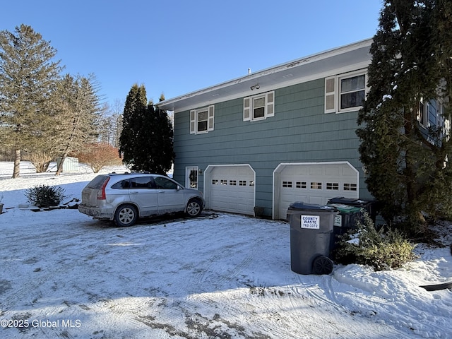 snow covered property with a garage