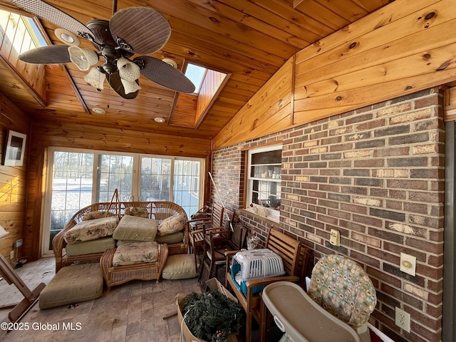 sunroom featuring ceiling fan, wooden ceiling, and vaulted ceiling with skylight