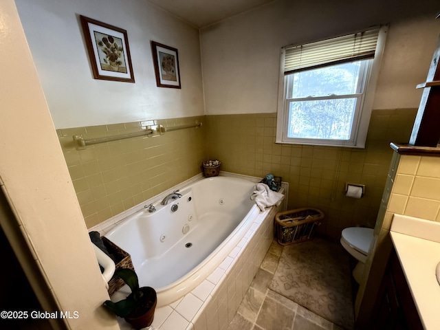 bathroom with tile patterned floors, tile walls, toilet, vanity, and tiled bath