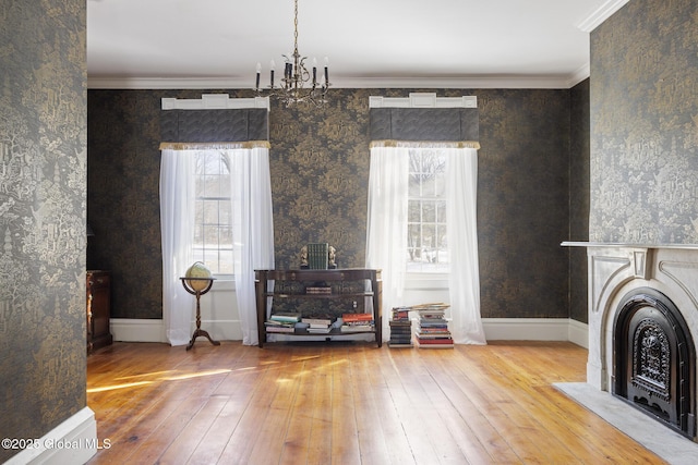 interior space featuring a notable chandelier, wood-type flooring, and ornamental molding