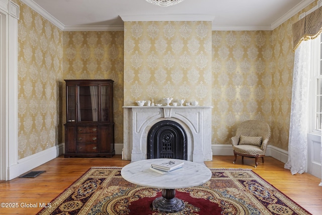 sitting room with hardwood / wood-style flooring and crown molding