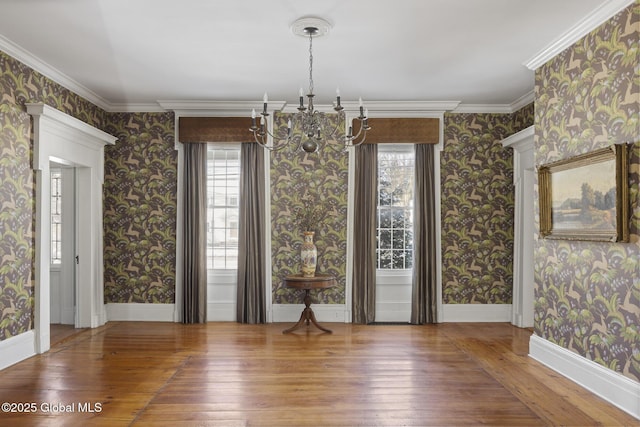 unfurnished dining area featuring crown molding, hardwood / wood-style floors, and a notable chandelier