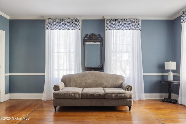 living area featuring a wealth of natural light, hardwood / wood-style floors, and crown molding