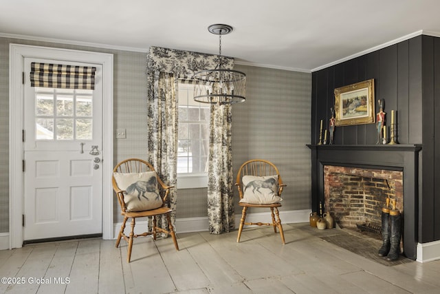 living area featuring an inviting chandelier, light hardwood / wood-style flooring, and ornamental molding