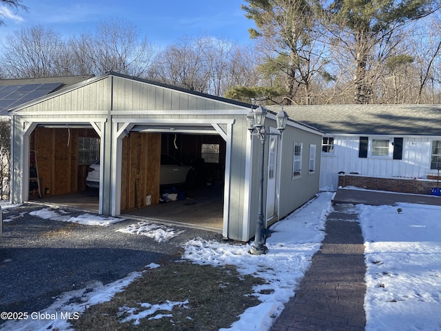 view of snowy exterior featuring a garage