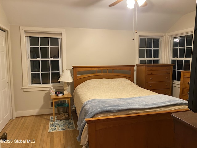 bedroom with ceiling fan, light hardwood / wood-style floors, and vaulted ceiling