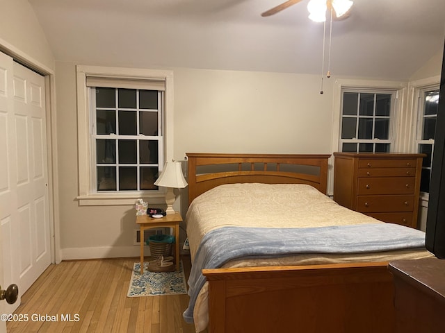 bedroom featuring a closet, lofted ceiling, ceiling fan, and light hardwood / wood-style flooring