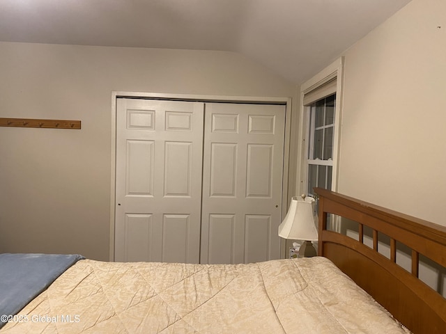 bedroom with lofted ceiling and a closet