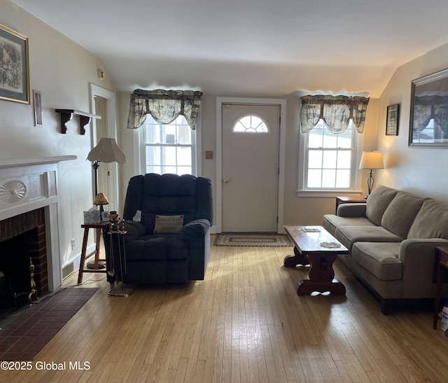 living room featuring a fireplace, vaulted ceiling, and wood-type flooring