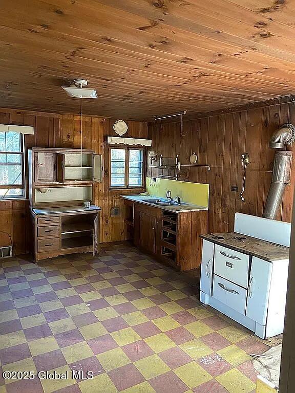 kitchen with wood ceiling, wooden walls, and a wealth of natural light