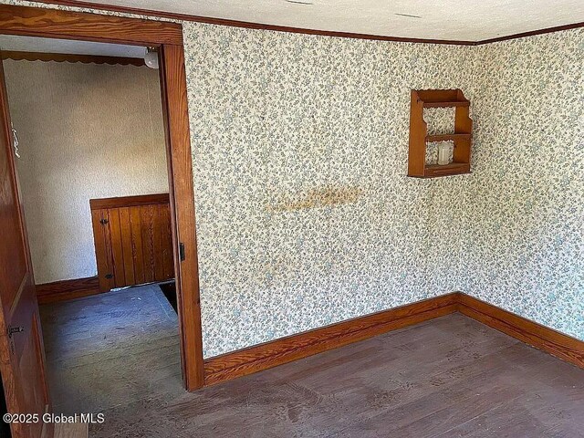 spare room with dark wood-type flooring and ornamental molding